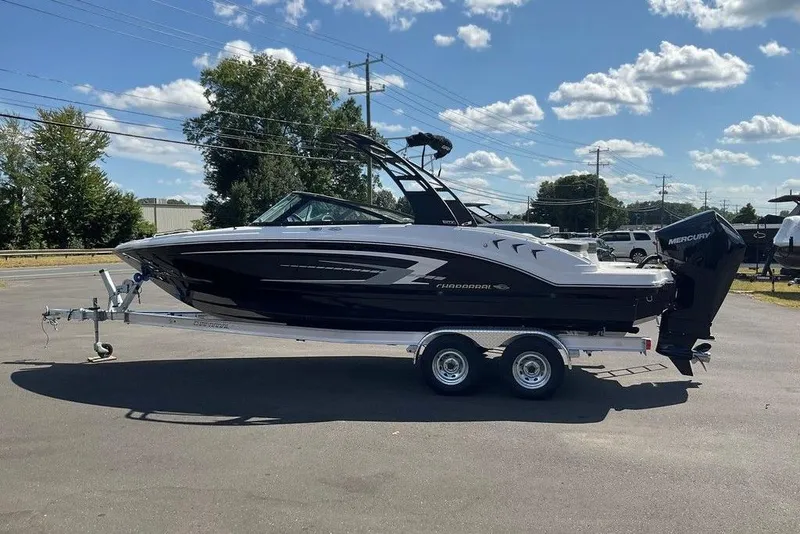 Slide: The Image of 2026 Chaparral 23 SSi OB boat on trailer, parked outdoors under a blue sky. - 4