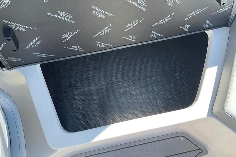 Slide: The Image of 2026 Chaparral 23 SSi OB boat interior storage compartment with branded cover. - 41