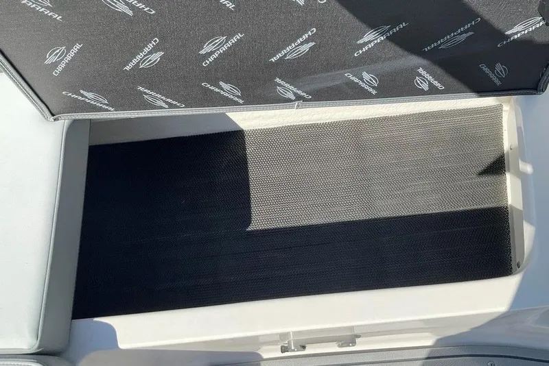 Slide: The Image of 2026 Chaparral 23 SSi OB boat storage compartment with branded cover. - 42