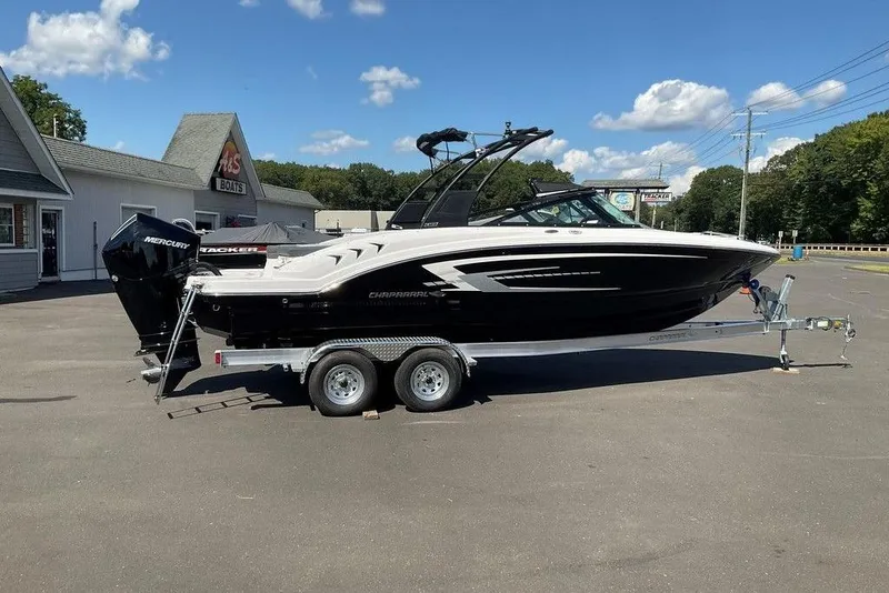 Slide: The Image of 2026 Chaparral 23 SSi OB boat on trailer, parked outside dealership under blue sky. - 6