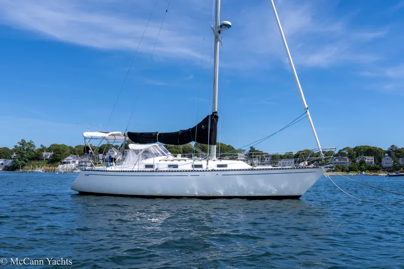 Slide: The Image of 1985 Tartan 34-2 sailboat anchored on calm water under a clear blue sky. - 1