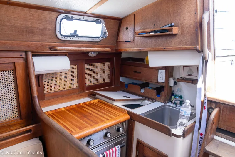 Slide: The Image of Compact galley kitchen in 1985 Tartan 34-2 yacht with wooden cabinetry and stainless steel sink. - 10