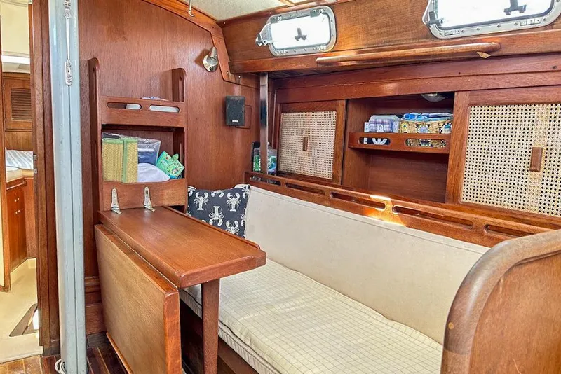 Slide: The Image of Cozy 1985 Tartan 34-2 sailboat interior with wooden furnishings and storage shelves. - 15