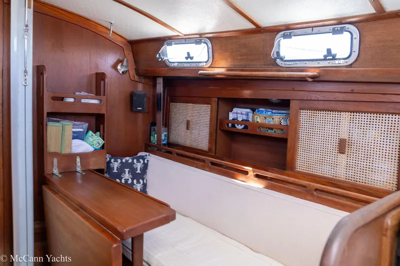 Slide: The Image of Cozy interior of 1985 Tartan 34-2 yacht with wooden furnishings and storage shelves. - 21