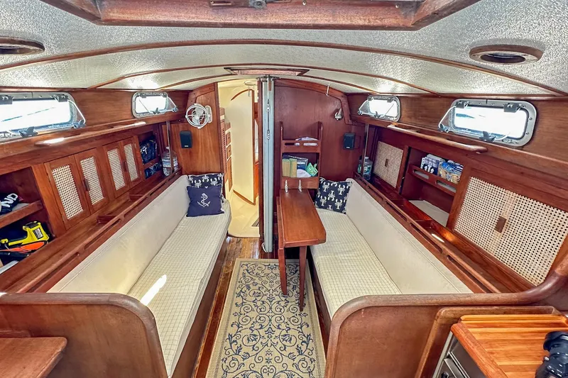 Slide: The Image of Interior of a 1985 Tartan 34-2 sailboat with wooden furnishings and cozy seating. - 24