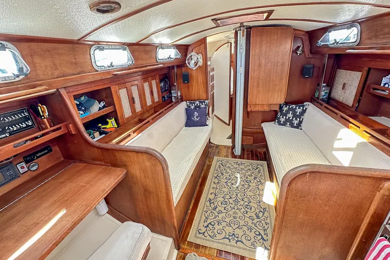 Slide: The Image of Interior of a 1985 Tartan 34-2 sailboat with wooden furnishings and cozy seating. - 25