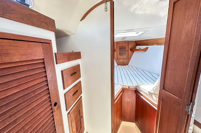 Slide: The Image of Interior of 1985 Tartan 34-2 sailboat with wooden cabinetry and cozy sleeping area. - 27