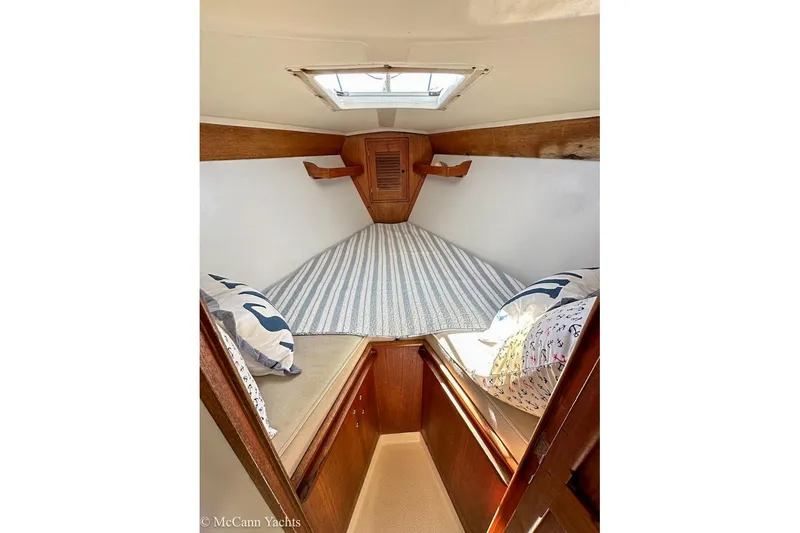 Slide: The Image of Cozy cabin interior of 1985 Tartan 34-2 sailboat with striped bedding and pillows. - 29