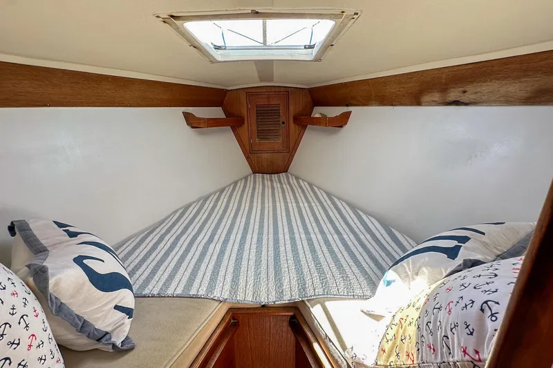 Slide: The Image of Cozy cabin interior of 1985 Tartan 34-2 sailboat with striped bedding and nautical pillows. - 30