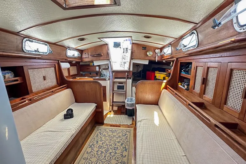 Slide: The Image of Interior of 1985 Tartan 34-2 sailboat with wood paneling and cozy seating. - 32