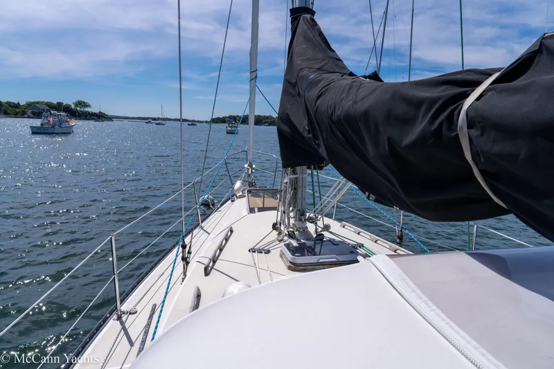 Slide: The Image of 1985 Tartan 34-2 sailboat on calm water under a clear blue sky. - 39