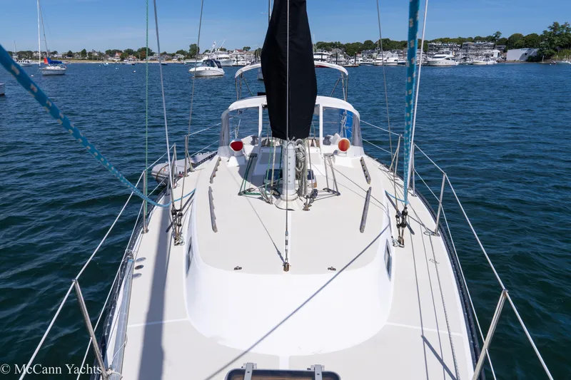 Slide: The Image of 1985 Tartan 34-2 sailboat on calm water, view from deck, marina in background. - 41