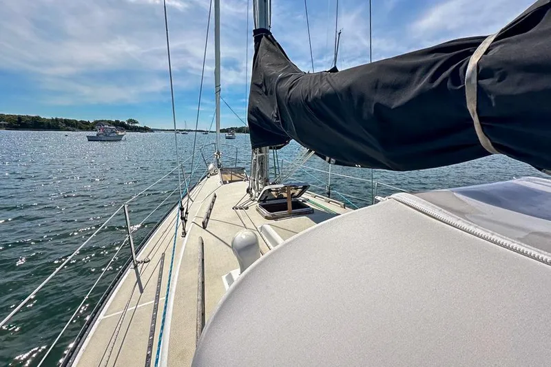 Slide: The Image of Sailboat Tartan 34-2 from 1985 on calm waters under a clear sky. - 43