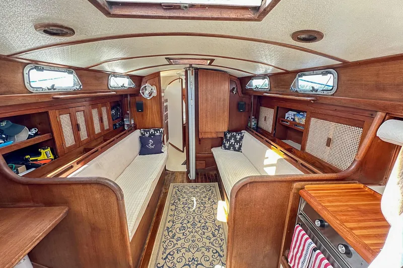 Slide: The Image of Interior of a 1985 Tartan 34-2 sailboat with wooden furnishings and cozy seating. - 7