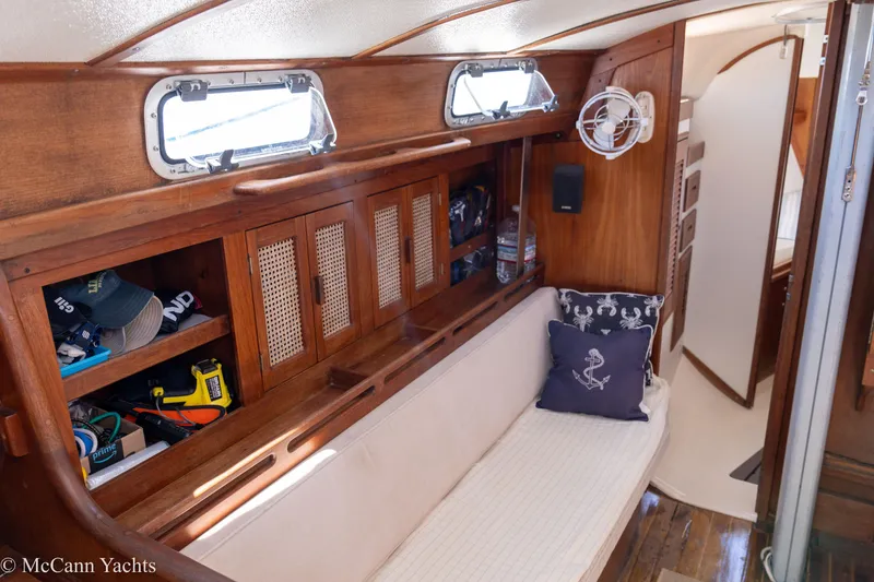 Slide: The Image of Interior of 1985 Tartan 34-2 sailboat with wooden cabinetry and cozy seating area. - 8