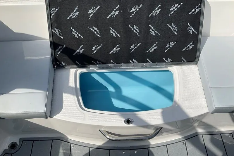 Slide: The Image of 2026 Chaparral 21 SSi OB boat storage compartment with branded cover open. - 17