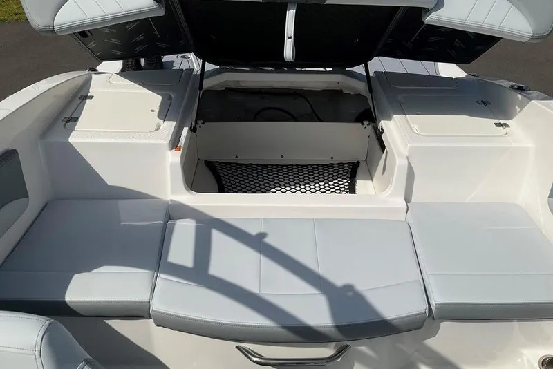 Slide: The Image of 2026 Chaparral 21 SSi OB boat interior with open storage compartments and cushioned seating. - 21