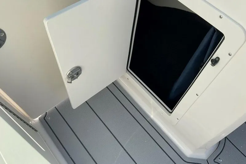 Slide: The Image of Open storage compartment on 2026 Chaparral 21 SSi OB boat, featuring sleek design. - 8
