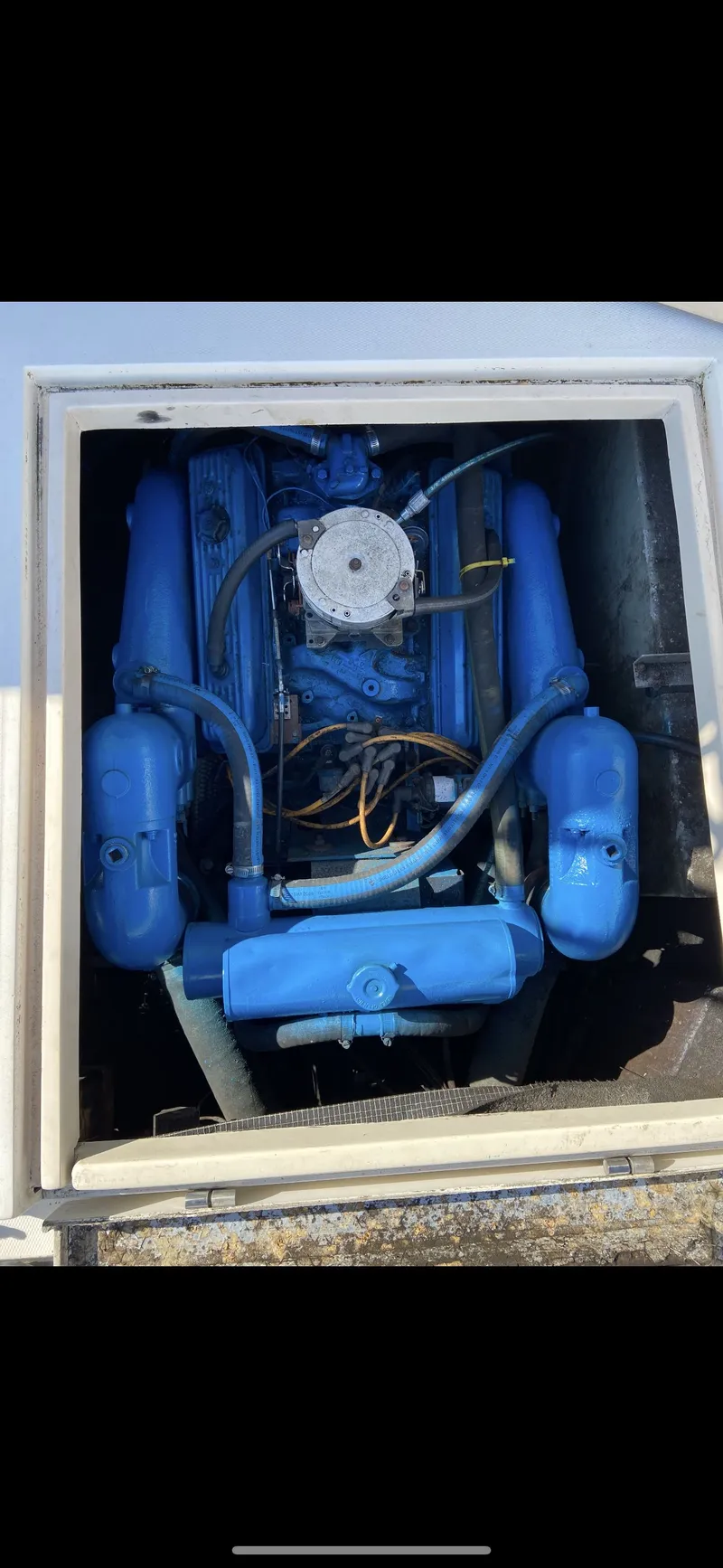 Slide: The Image of Engine of a 1987 Phoenix 29 Convertible boat, painted blue. - 12