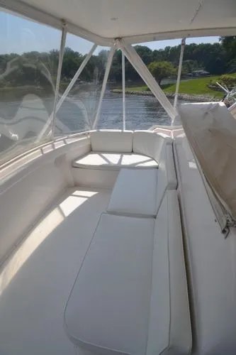 Slide: The Image of 1995 Bertram 50 Convertible yacht interior with white seating and scenic water view. - 14