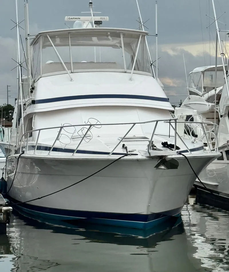 Slide: The Image of 1995 Bertram 50 Convertible yacht docked at marina, overcast sky. - 2