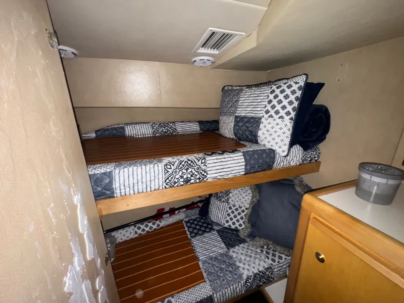 Slide: The Image of Interior of 1995 Bertram 50 Convertible with bunk beds and patterned bedding. - 28