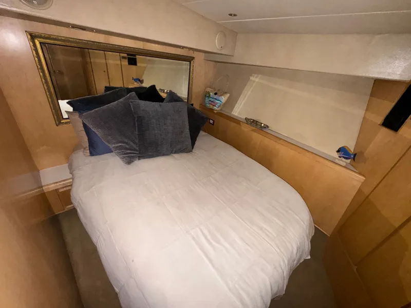 Slide: The Image of Cozy bedroom in 1995 Bertram 50 Convertible yacht with plush pillows and wooden accents. - 30