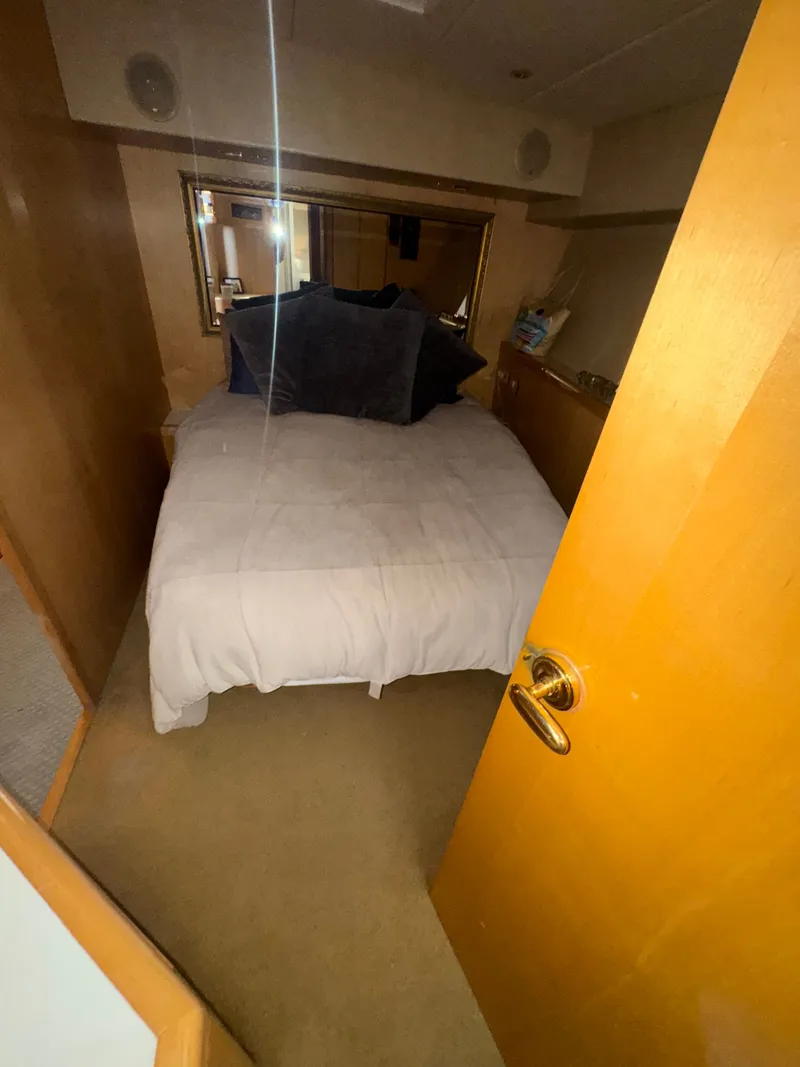 Slide: The Image of Cozy bedroom in 1995 Bertram 50 Convertible yacht with plush bedding and wooden accents. - 31