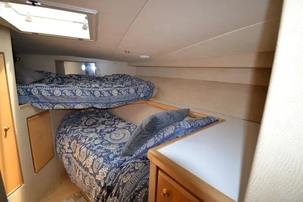 Slide: The Image of 1995 Bertram 50 Convertible cabin with bunk beds and patterned bedding. - 33