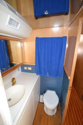 Slide: The Image of 1995 Bertram 50 Convertible yacht bathroom with sink, toilet, and blue accents. - 36