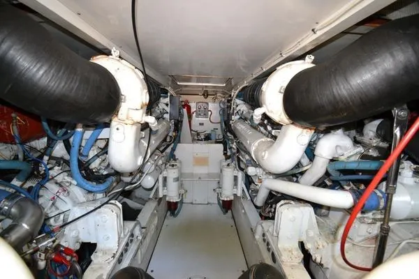 Slide: The Image of Engine room of a 1995 Bertram 50 Convertible yacht, showcasing dual engines and piping. - 38