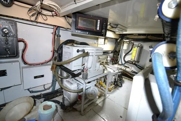 Slide: The Image of Engine room of a 1995 Bertram 50 Convertible yacht, showcasing equipment and wiring. - 39