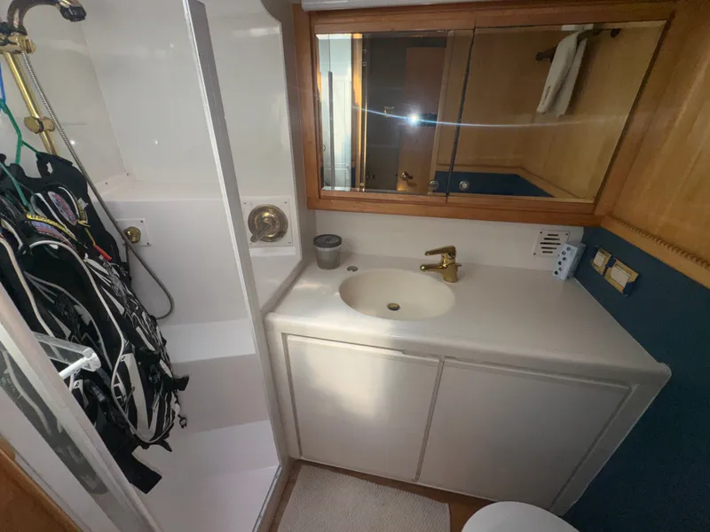 Slide: The Image of Bathroom interior of a 1995 Bertram 50 Convertible yacht with sink and shower. - 46