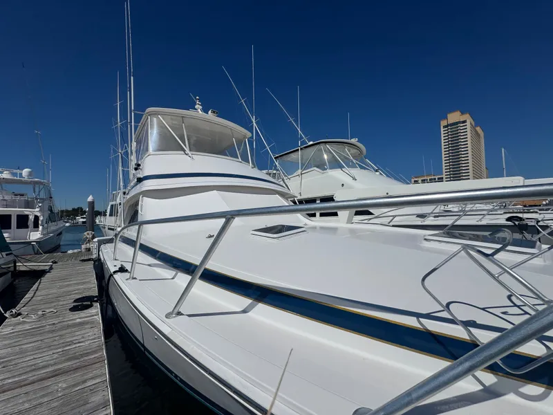Slide: The Image of 1995 Bertram 50 Convertible yacht docked at marina under clear blue sky. - 47