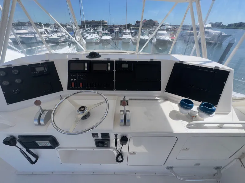 Slide: The Image of Cockpit of a 1995 Bertram 50 Convertible yacht with steering wheel and navigation controls. - 9