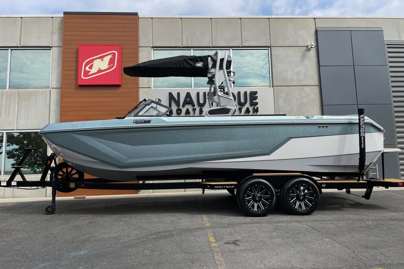 The Image of 2026 Nautique Super Air Nautique GS24 boat on trailer outside dealership. - 1