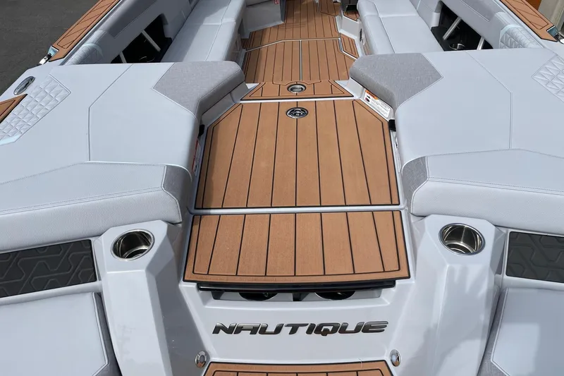 Slide: The Image of 2026 Nautique Super Air Nautique GS24 boat interior with sleek seating and wood accents. - 4