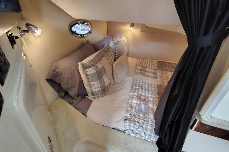 Slide: The Image of Cozy cabin interior of 2008 Regal 2565 Window Express with plaid bedding and soft lighting. - 25