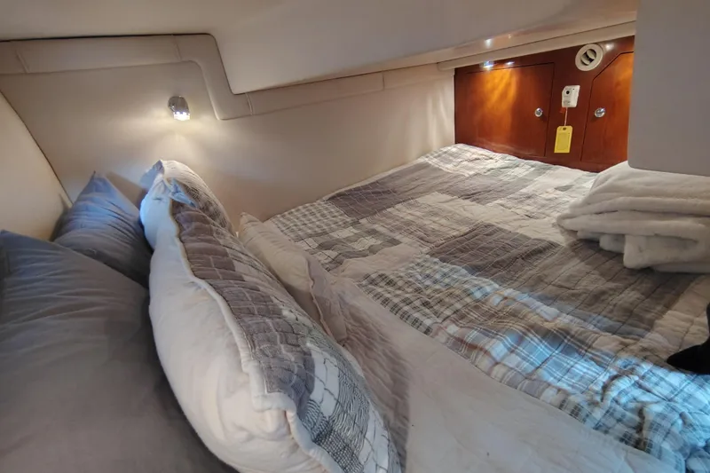 Slide: The Image of Cozy cabin interior of 2008 Regal 2565 Window Express with plush bedding and ambient lighting. - 26