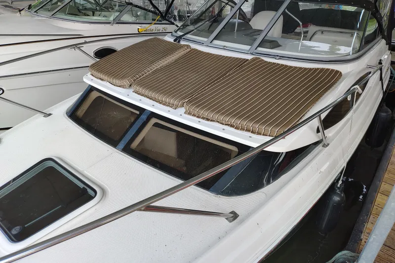 Slide: The Image of 2008 Regal 2565 Window Express boat docked with striped sun pads on deck. - 8