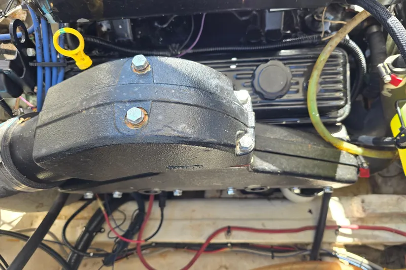 Slide: The Image of Engine components of a 1984 Bayliner 2802 Trophy boat, featuring hoses and bolts. - 13