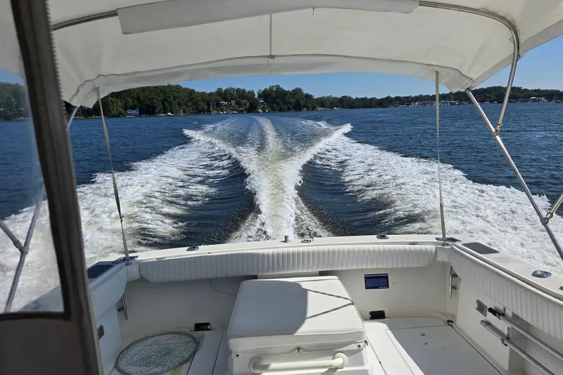 Slide: The Image of 1984 Bayliner 2802 Trophy boat cruising on a lake, leaving a wake behind. - 25