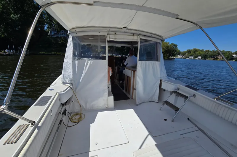 Slide: The Image of 1984 Bayliner 2802 Trophy boat with canopy, cruising on a serene lake. - 30
