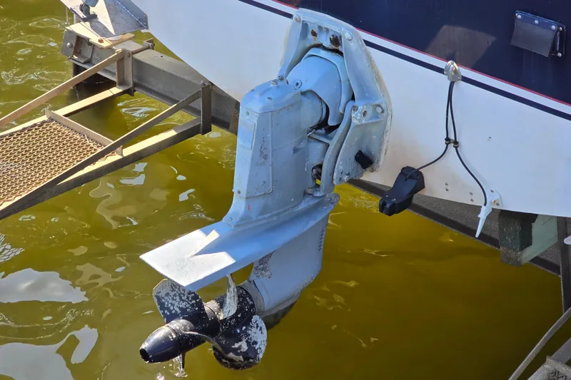 Slide: The Image of Outboard motor of 1984 Bayliner 2802 Trophy boat on a trailer by the water. - 8
