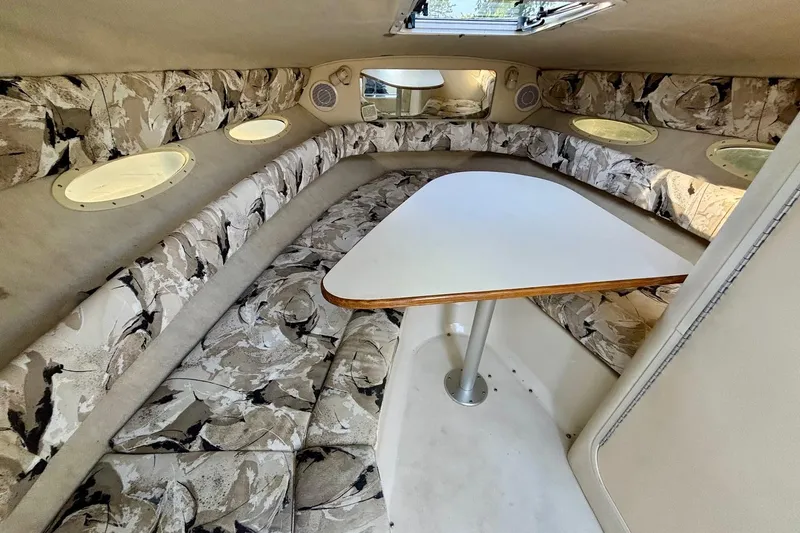 Slide: The Image of Interior of 1999 Sea Ray 260 Overnighter boat with patterned seating and table. - 13