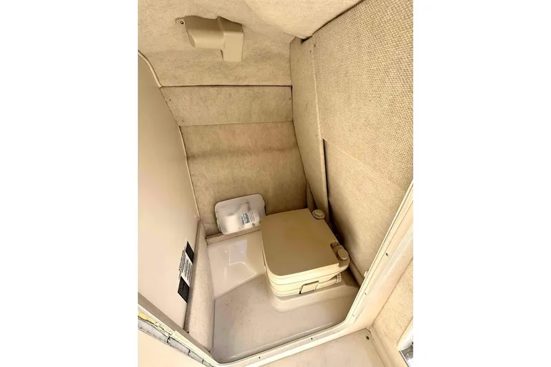 Slide: The Image of 1999 Sea Ray 260 Overnighter cabin interior with portable toilet. - 15