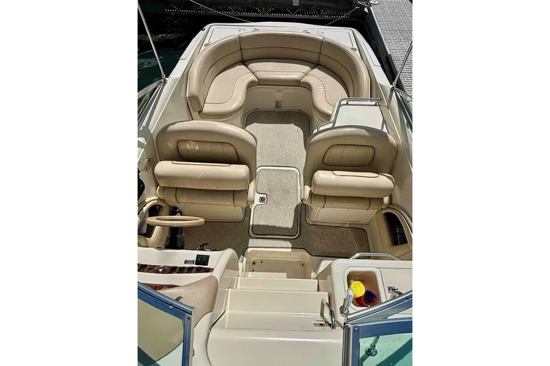 Slide: The Image of 1999 Sea Ray 260 Overnighter boat interior with beige seating and steering wheel. - 16