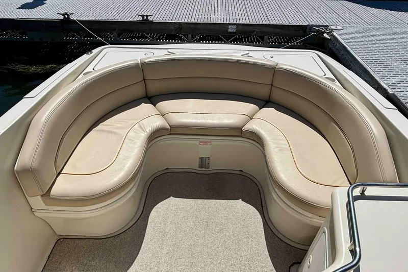 Slide: The Image of 1999 Sea Ray 260 Overnighter boat with beige cushioned seating area. - 17