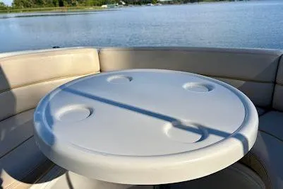 Slide: The Image of 1999 Sea Ray 260 Overnighter boat interior with round table on calm water. - 19