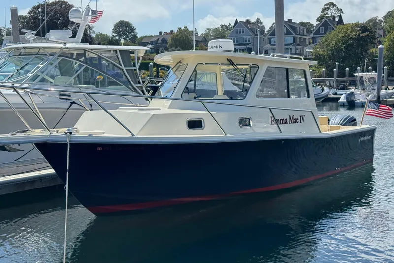 The Image of 2026 NorthCoast 285 HT boat docked in a marina, featuring sleek design and American flag. - 0